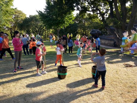 These children are playing a traditional Korean game called tuho, where arrows or sticks are thrown into a canister. It is said to have originated in China and was played among royal and higher class families.
